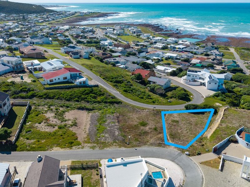 An aerial view of a vacant residential plot situated in a coastal neighborhood, highlighting its location and proximity to the ocean.