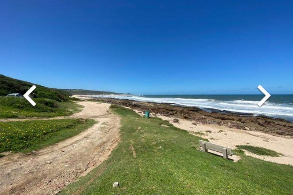 A scenic coastal view featuring a rocky shoreline, natural vegetation, and expansive ocean vistas.