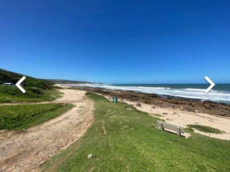 A scenic coastal view featuring a rocky shoreline, natural vegetation, and expansive ocean vistas.