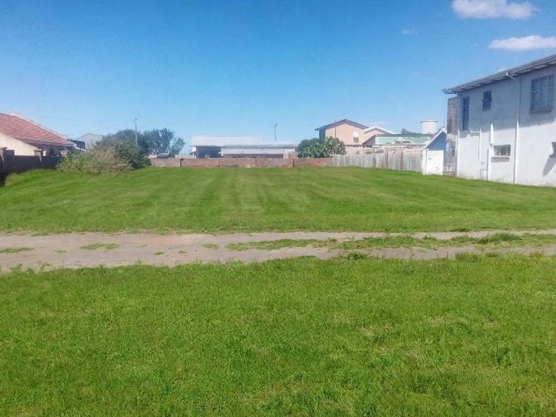 A level, grassed residential vacant plot situated in a suburban area, ready for development.