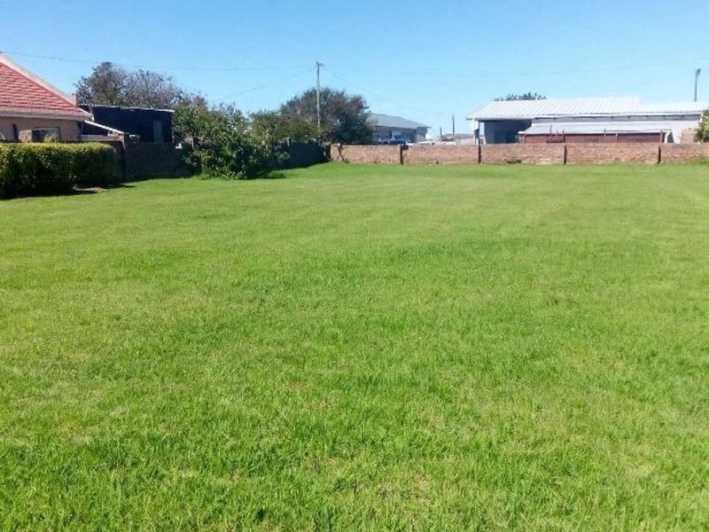 A spacious, level residential plot featuring a well-maintained lawn and secure brick boundary walls, offering a clear space for potential development.