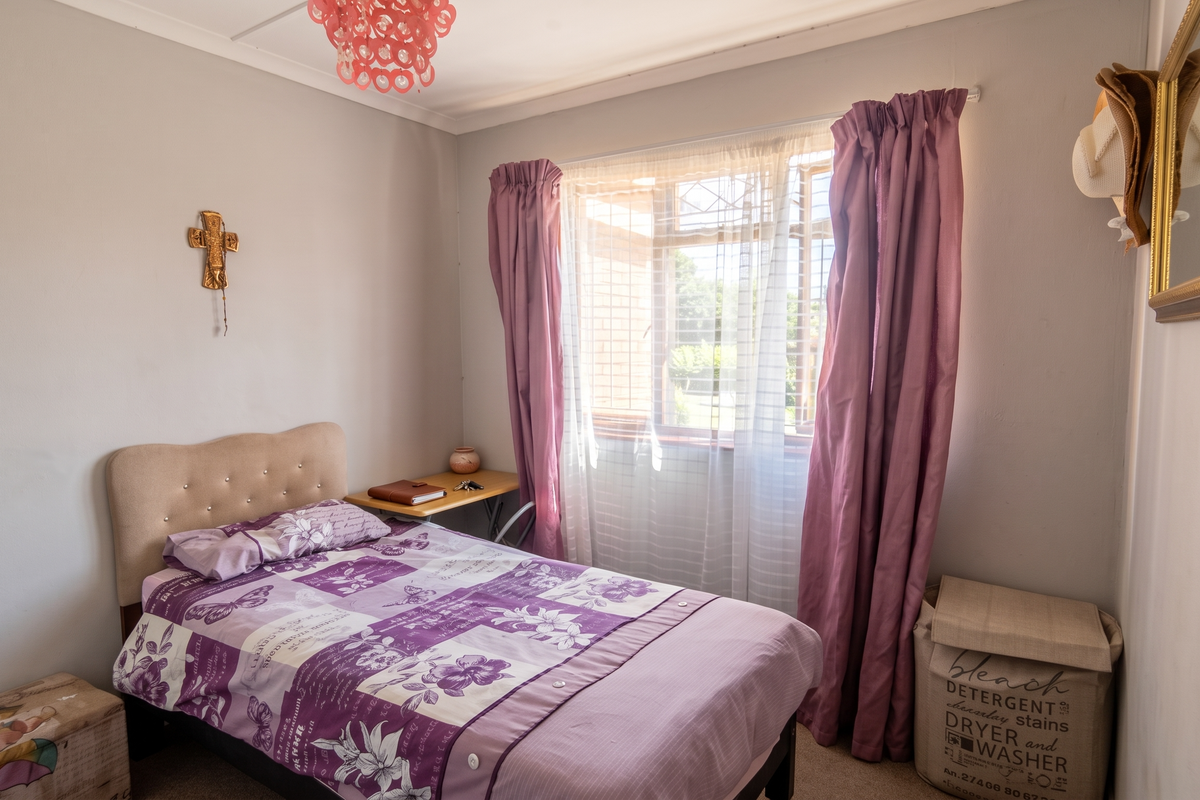 A cozy bedroom featuring carpeted flooring, a window with curtain rails, and decorative coving, offering a comfortable and functional living space.