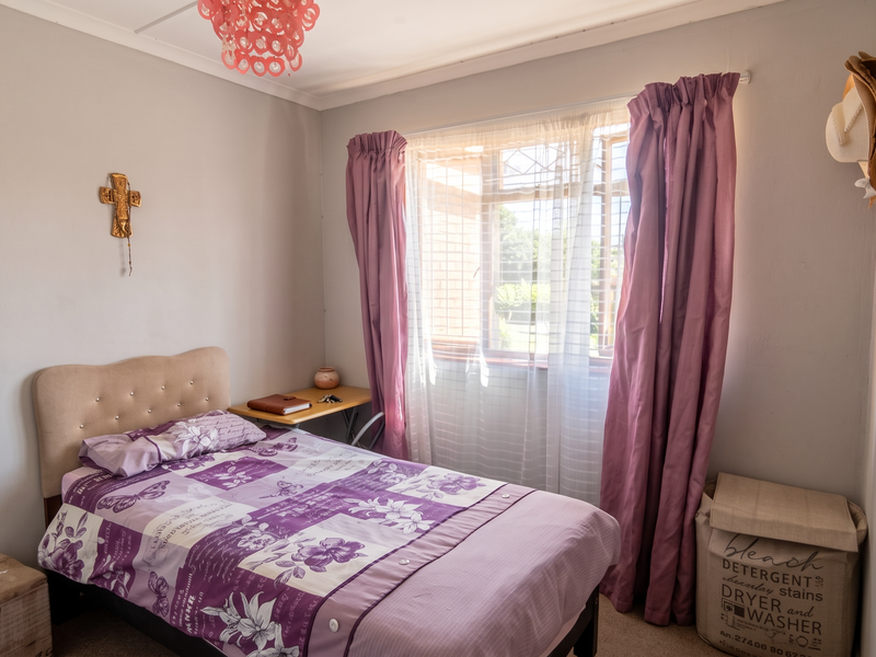 A cozy bedroom featuring carpeted flooring, a window with curtain rails, and decorative coving, offering a comfortable and functional living space.