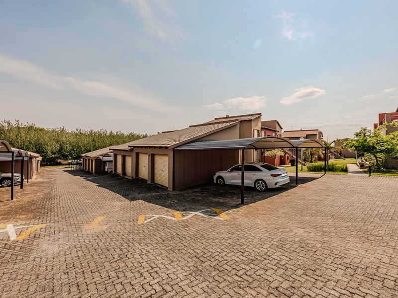 Exterior view of the apartment complex featuring paved driveways and covered carport parking bays.