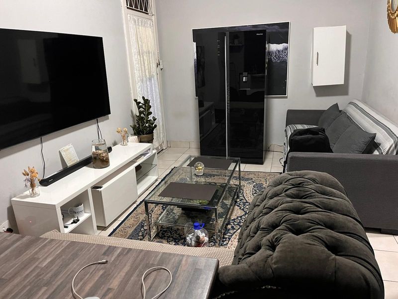 A living room area featuring tiled flooring and a wall-mounted storage cabinet, providing a functional space for relaxation.