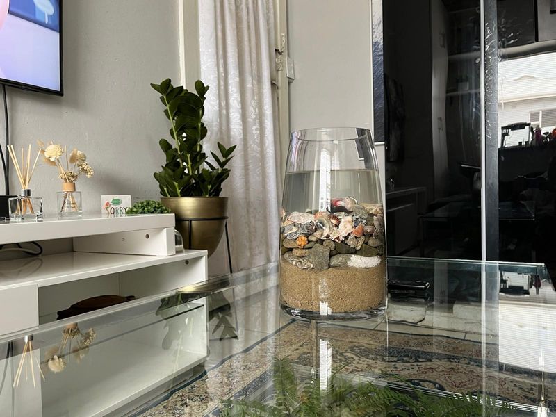 A view of a living room interior featuring tiled flooring and a sliding door, with a focus on decorative elements.