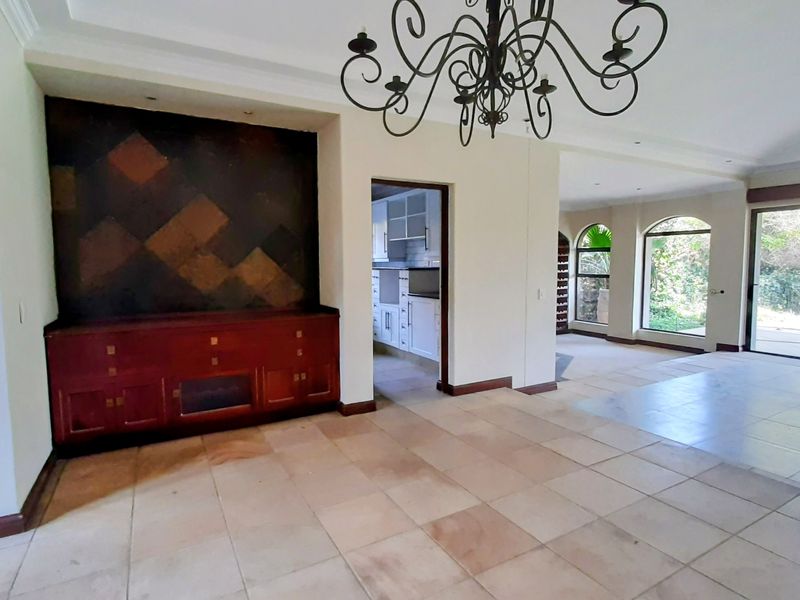 Spacious open-plan living area featuring tiled floors, built-in cabinetry, and large sliding doors leading to the outdoor space.