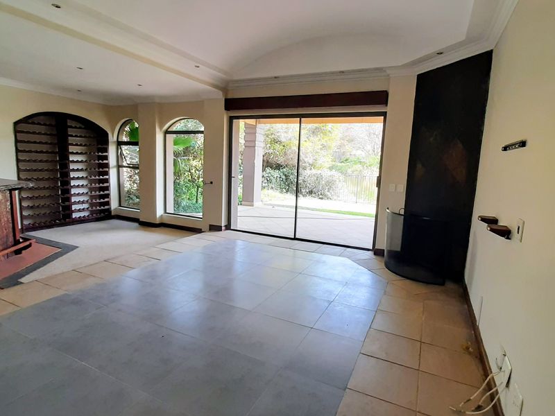 Spacious living area featuring a built-in bar, wine storage, fireplace, and large sliding doors opening to the patio.