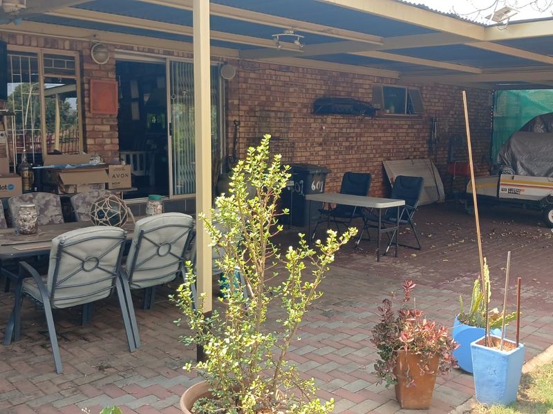 A covered outdoor patio area featuring brick walls, paved flooring, and direct access to the interior through sliding glass doors.