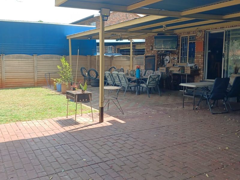 A covered outdoor patio area featuring brick paving and a built-in braai, providing a functional space for outdoor entertaining and relaxation.