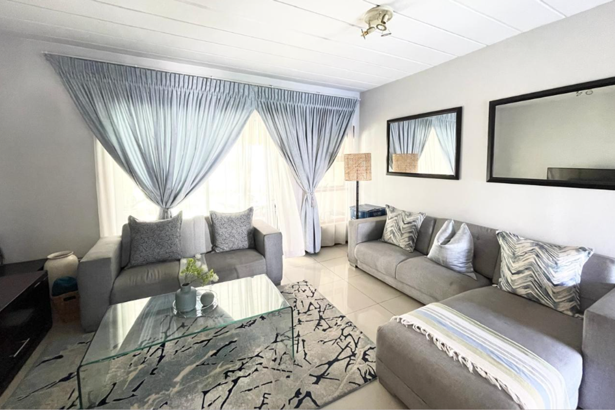 A bright and well-maintained living room featuring tiled flooring and neutral wall finishes, offering a comfortable and inviting space.