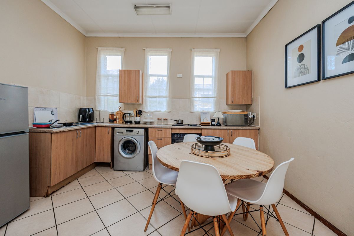 Functional kitchen featuring laminate cabinetry, tiled flooring, built-in oven, and hob, with an integrated space for a washing machine.