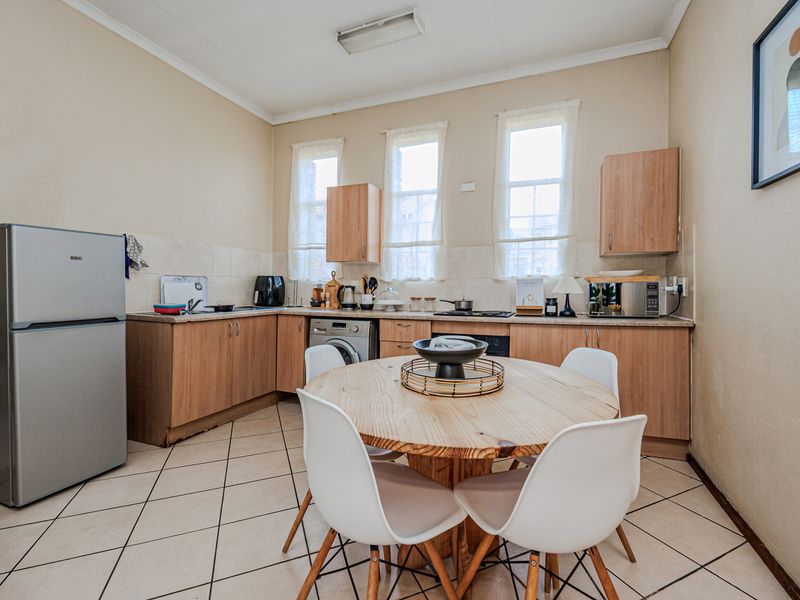 Open plan kitchen and dining area featuring laminate cabinetry, tiled flooring, and built-in cooking appliances in a functional, lived-in condition.