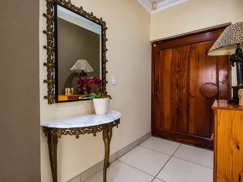 A welcoming entrance hall featuring tiled flooring and a solid wood front door with decorative coving.