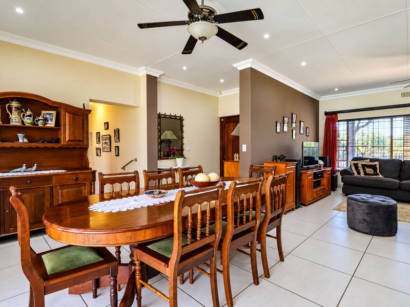 Spacious open-plan living and dining area featuring neutral tiled flooring, recessed lighting, and ceiling fans, creating a comfortable and functional family space.