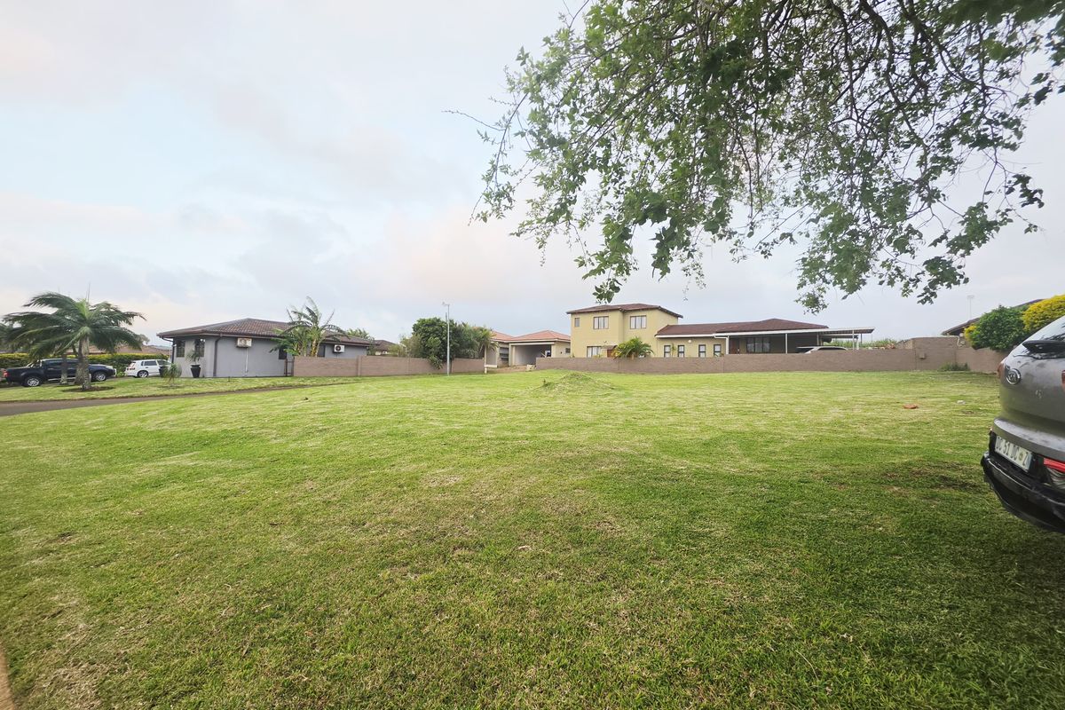 A spacious, well-maintained vacant residential plot featuring a level grass lawn and perimeter walling in a established neighborhood.