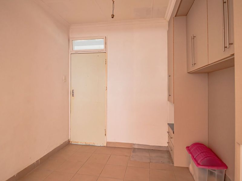 A functional laundry area featuring built-in cabinetry and tiled flooring, offering a clean and practical space for utility needs.