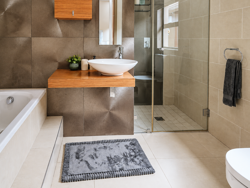 Modern bathroom featuring a floating vanity with a vessel sink, a built-in bathtub, and a separate glass-enclosed shower with neutral tiling.