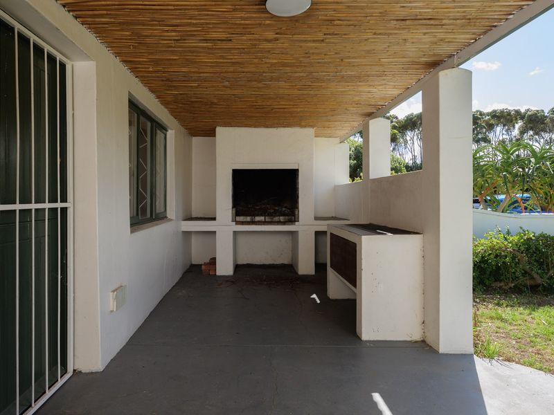 Covered outdoor patio featuring a built-in braai area, bamboo ceiling, and direct access to the garden.