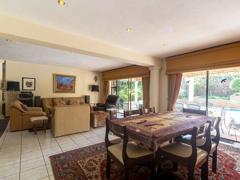 Spacious open-plan living and dining area featuring ceramic tile flooring, recessed lighting, and large sliding glass doors providing direct access to the pool patio.