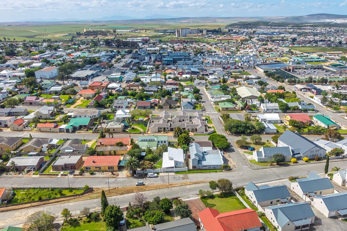 An elevated aerial view showcasing the surrounding residential neighborhood, street layout, and urban infrastructure of the property location.