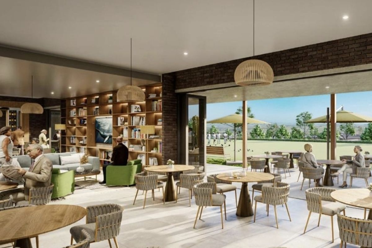 A modern open-plan living and dining area featuring exposed brick walls, built-in shelving, and seamless transition to an outdoor patio space.