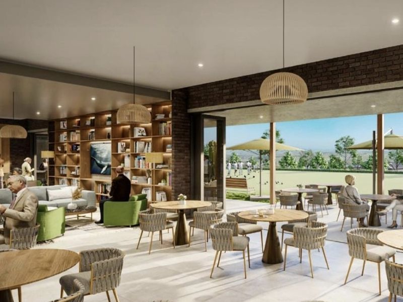 A modern open-plan living and dining area featuring exposed brick walls, built-in shelving, and seamless transition to an outdoor patio space.
