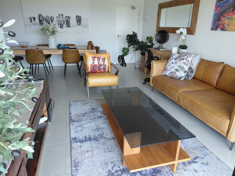 Spacious open-plan living and dining area featuring neutral tiled flooring and a bright, functional layout suitable for modern apartment living.