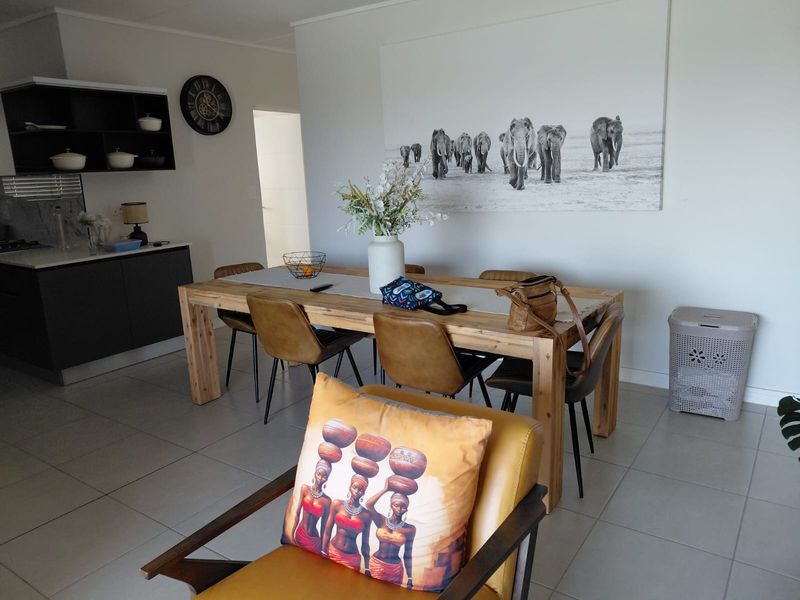 Open-plan living and dining area featuring tiled flooring and a modern kitchen with built-in cabinetry.