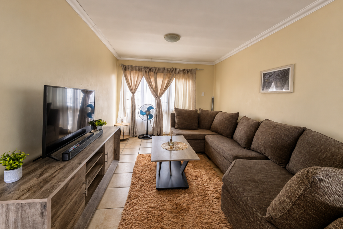 A comfortable living room featuring tiled flooring and classic ceiling cornicing, providing a neutral base for interior design updates.