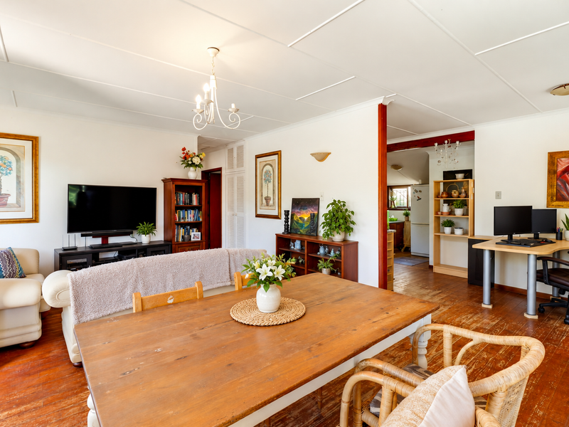 Open plan living and dining area featuring hardwood flooring, neutral walls, and direct access to the kitchen space.