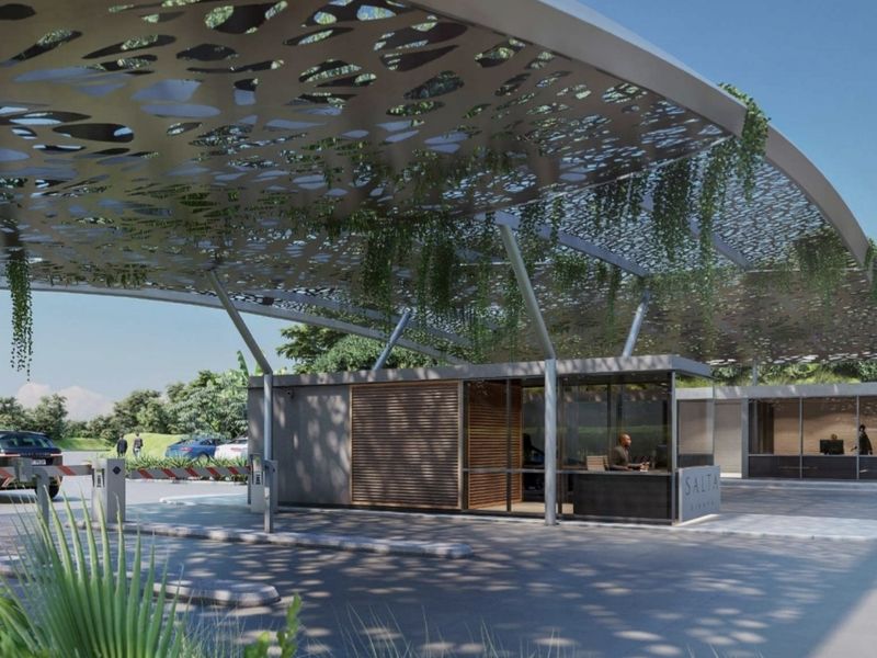 Modern residential estate security entrance featuring a decorative canopy, boom gate access control, and a contemporary guardhouse structure.