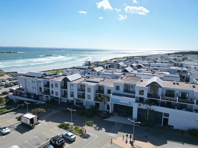 Aerial view of the Eden on the Bay apartment complex, showcasing its coastal location, modern architecture, and proximity to the beach.