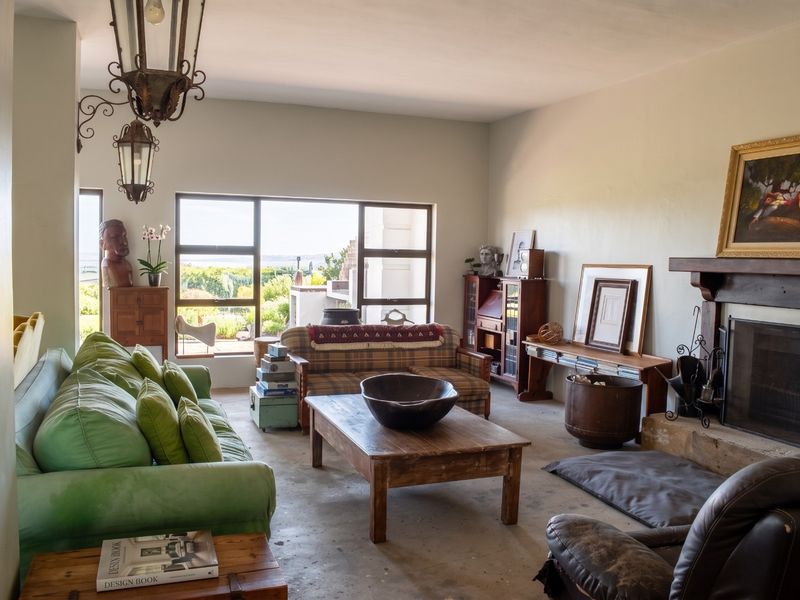 Spacious living room featuring a fireplace, large windows with natural light, and industrial-style concrete flooring, offering a versatile space for relaxation.