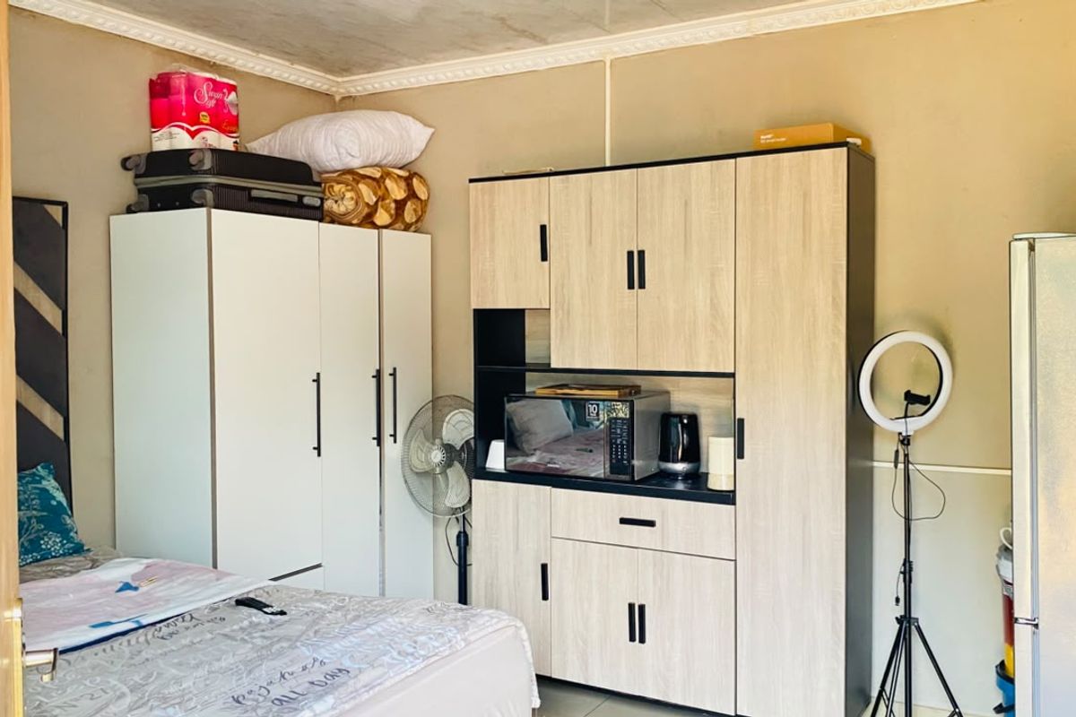 A bedroom featuring a built-in wardrobe and decorative crown molding, providing functional storage space within the room.