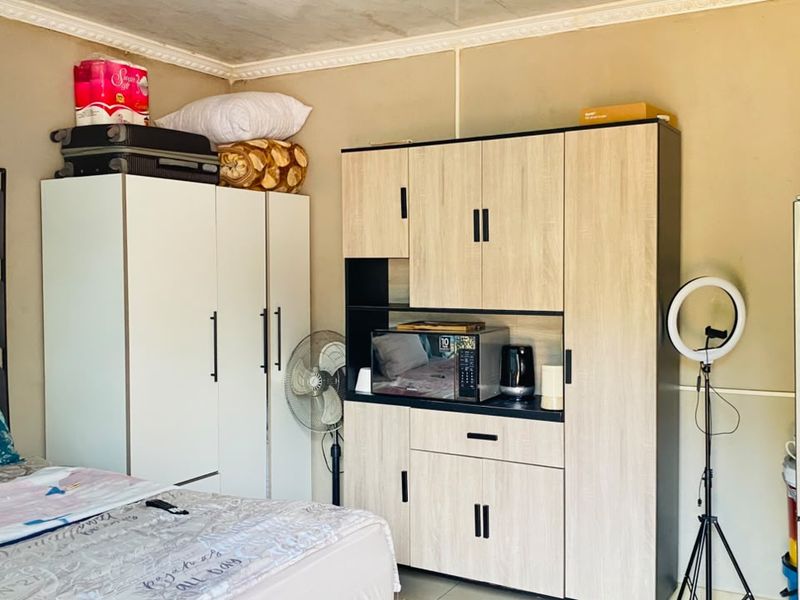 A bedroom featuring a built-in wardrobe and decorative crown molding, providing functional storage space within the room.