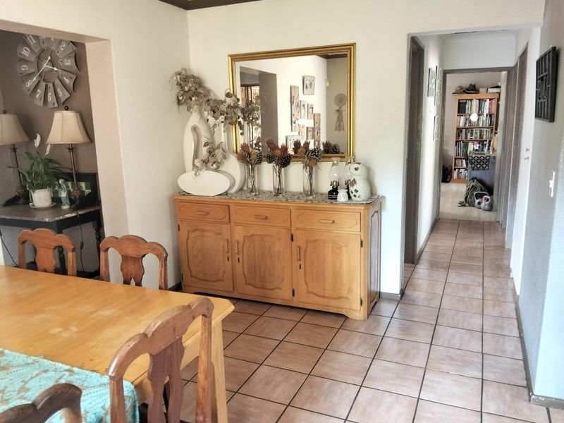 Dining area featuring tiled flooring and an open archway leading to an adjacent space, providing a functional layout for family meals.