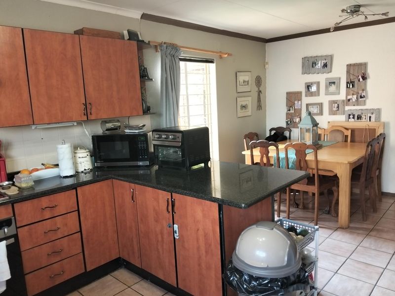 Open-plan kitchen and dining area featuring laminate cabinetry, granite countertops, and tiled flooring, offering a functional layout for daily living and dining.