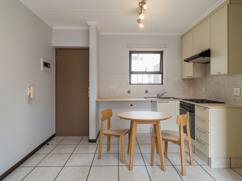 A functional kitchen featuring built-in cabinetry, tiled flooring, a tiled backsplash, and integrated appliances including an oven and hob.