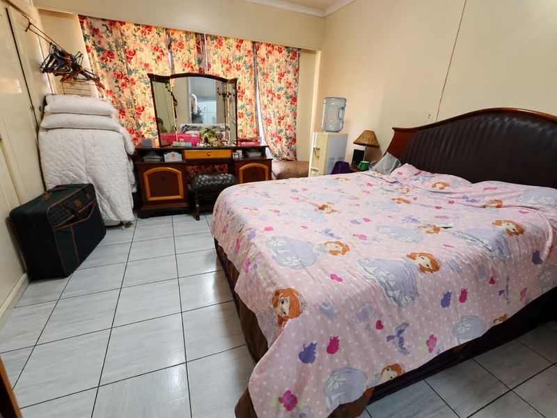 A bedroom featuring tiled flooring and a built-in wardrobe, offering a functional space ready for a modern update.