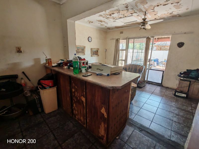 Open plan living area featuring a built-in breakfast bar, tiled flooring, and access to the patio through a sliding glass door.