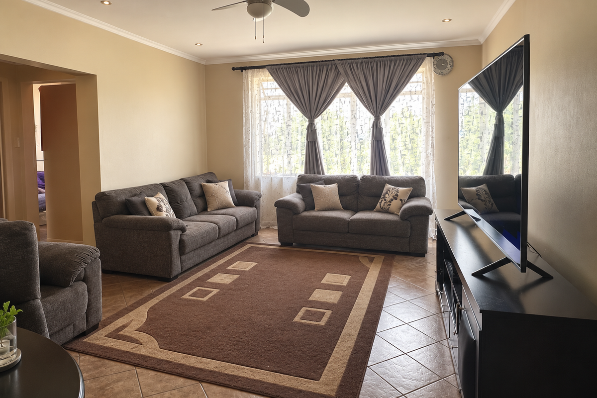 A well-maintained living room featuring tiled flooring, recessed ceiling lighting, and a central ceiling fan, offering a comfortable and functional living space.