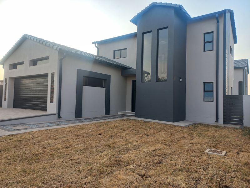 Modern double-story residential home featuring a contemporary facade, double garage, paved driveway, and clean architectural lines.