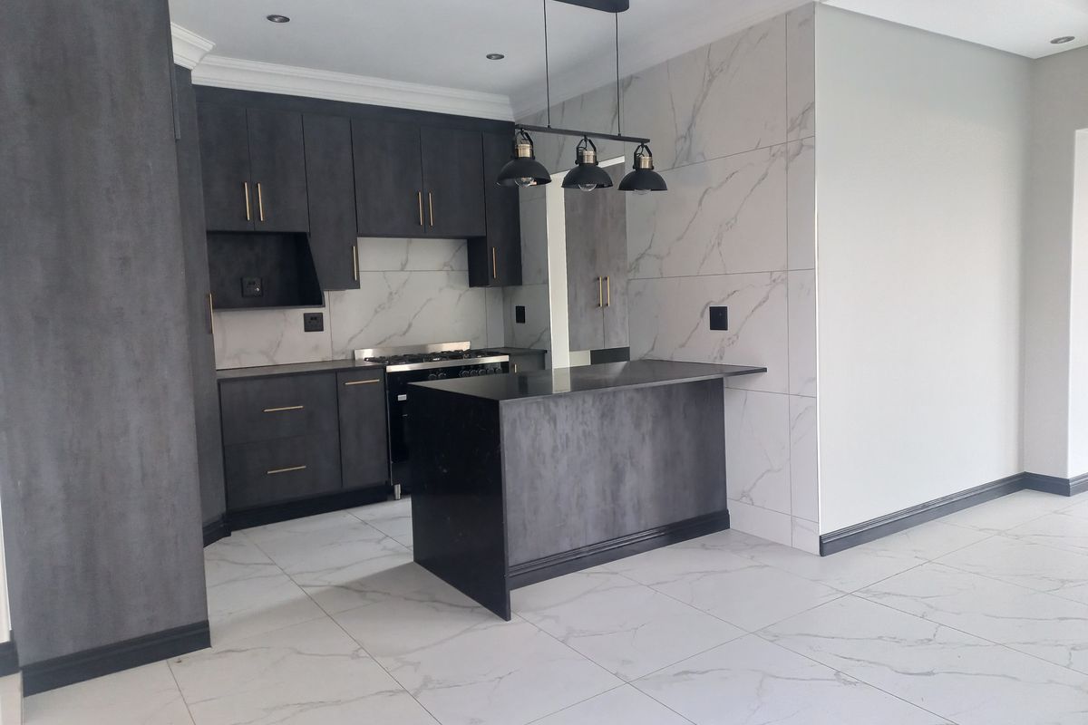 Modern kitchen featuring dark matte cabinetry, a central island, marble-look wall and floor tiles, and integrated gas cooking appliances.