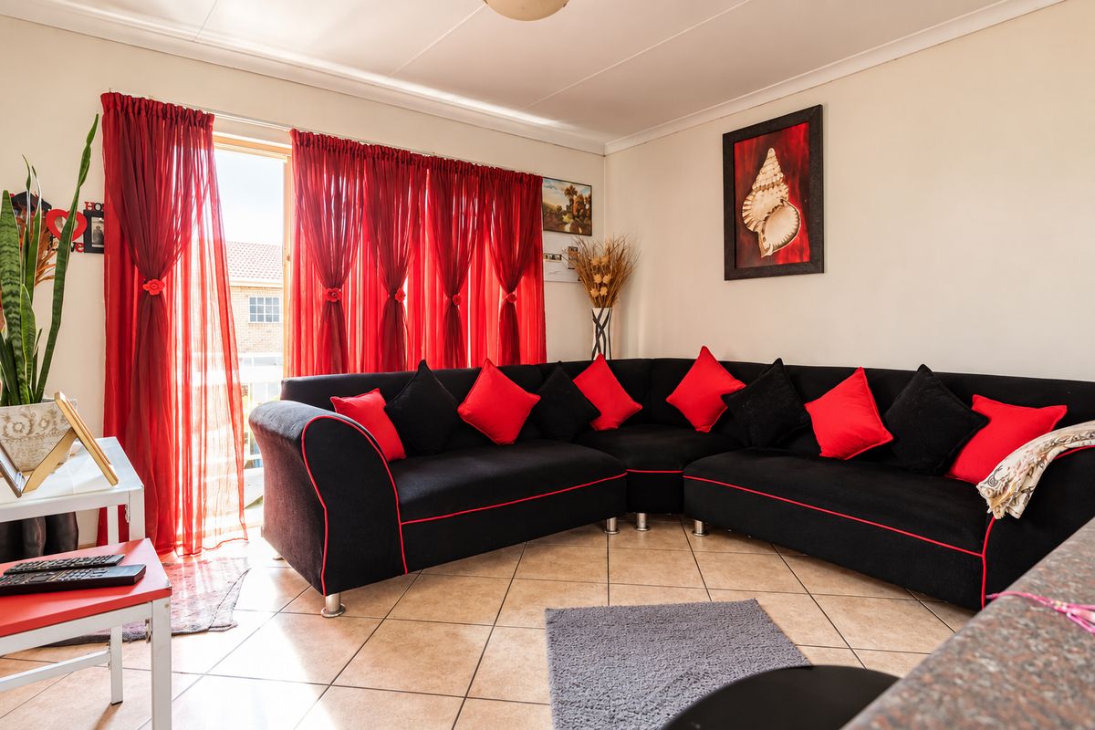 A living room featuring tiled flooring and a sliding glass door providing access to the exterior.