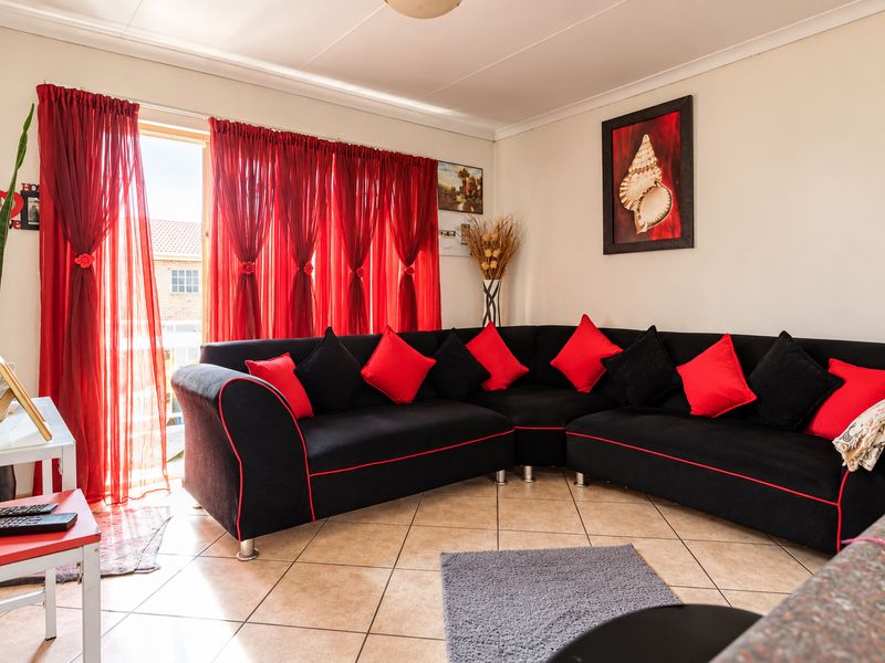 A living room featuring tiled flooring and a sliding glass door providing access to the exterior.