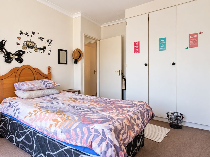 A bedroom featuring built-in cupboards, carpeted flooring, and coving, providing a functional space with ample storage.