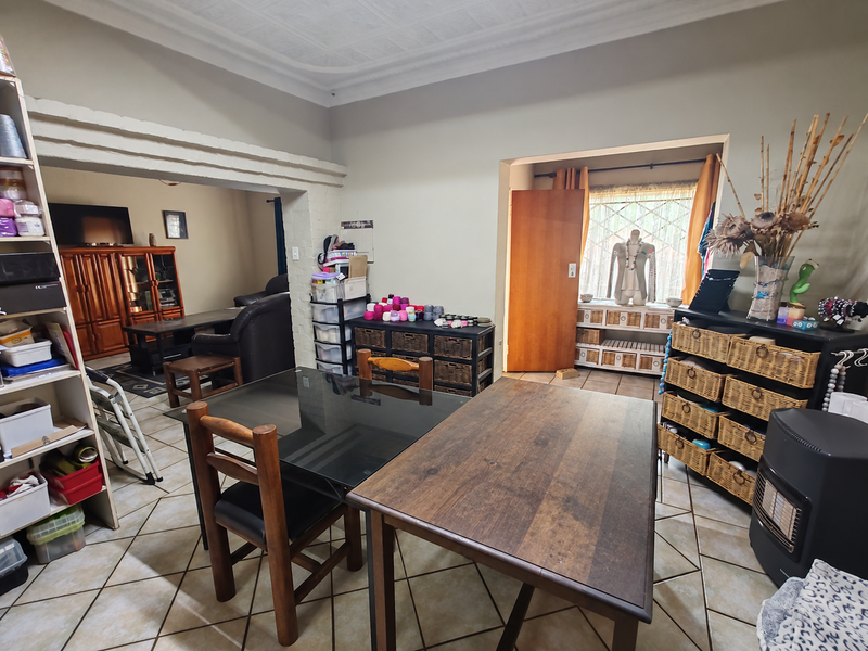 Open plan living and dining area featuring tiled flooring, a decorative ceiling, and a distinctive brick archway connecting the spaces.