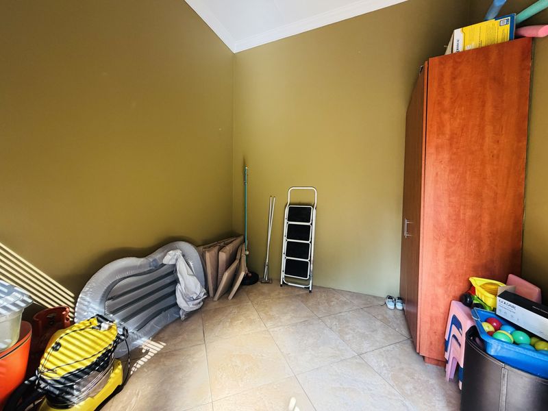 A utility space featuring tiled flooring and a built-in storage cupboard, suitable for use as a laundry, pantry, or general storage area.