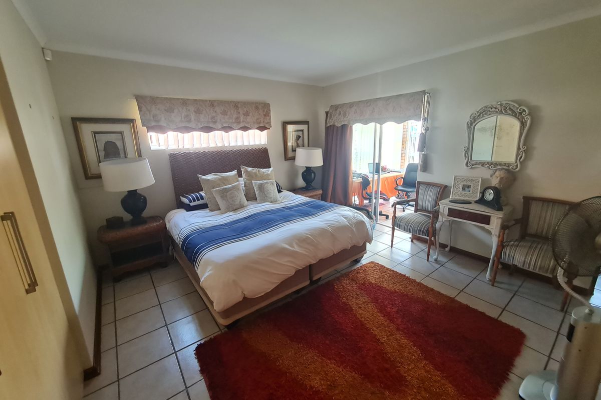 Spacious bedroom featuring tiled flooring, built-in storage, and direct access to an outdoor patio area through sliding glass doors.